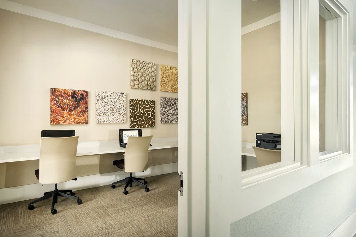 Business center with interior facing windows, computers, and a printer