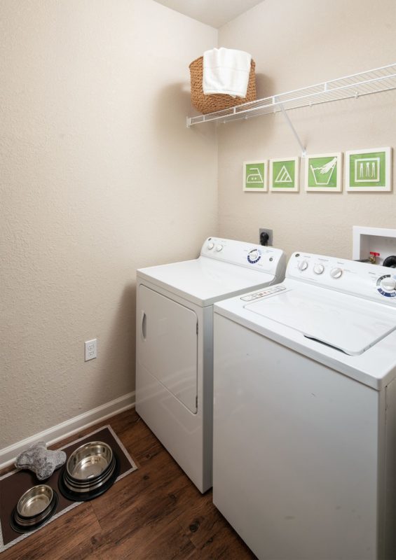 Side-by-side top loading washer and side loading dryer with wire shelf above